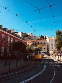 Railroad tracks by buildings in city against sky