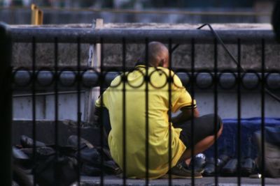 Rear view of man standing against yellow wall