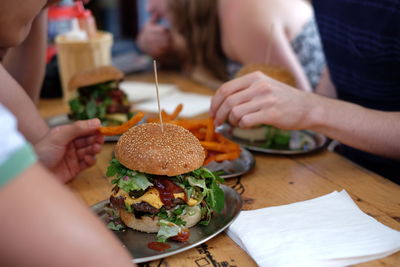 High angle view of burger on table surrounded by people