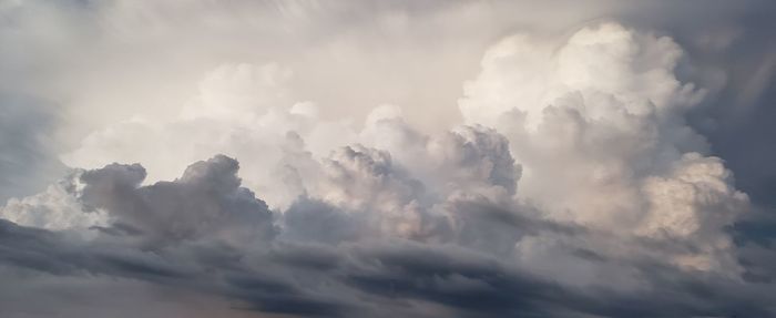 Low angle view of sunlight streaming through clouds