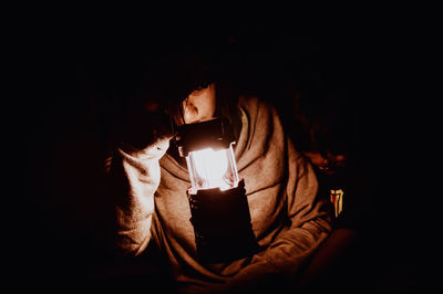 Close-up of lit candle in darkroom