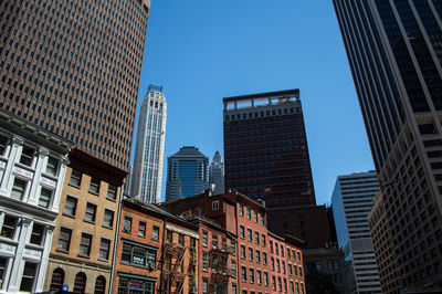 Low angle view of skyscrapers against clear blue sky