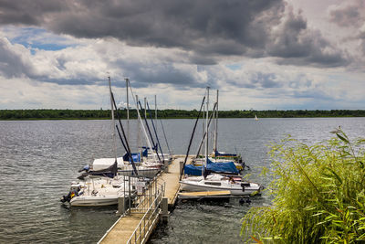 Boats moored on river against sky