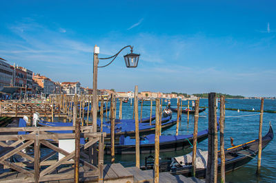 View of venice lagoon with pier and gondolas in venice, italy.