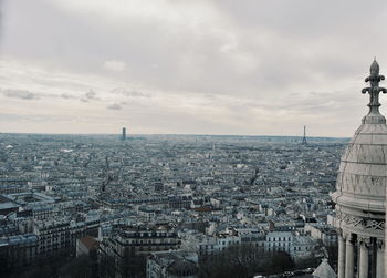 High angle view of city buildings against cloudy sky