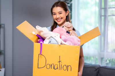 Portrait of smiling young woman holding gift box