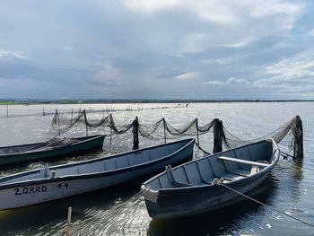 Boats moored in sea against sky