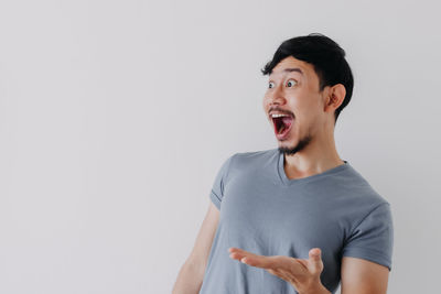 Young man looking away against white background