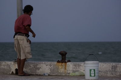 Man standing by sea against clear sky