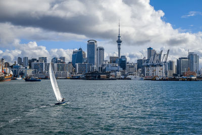 City at waterfront against cloudy sky