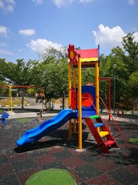 View of playground in park against blue sky