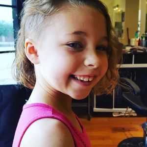 Close-up portrait of happy girl at salon