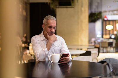 Man holding coffee cup in restaurant