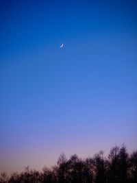 Low angle view of moon against clear blue sky