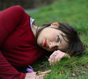 Portrait of young woman lying on field