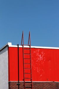 Red metal structure against clear blue sky