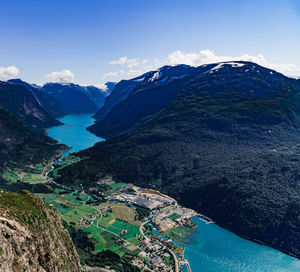 High angle view of buildings and mountains against blue sky