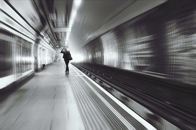 Rear view of man walking in tunnel