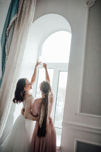 Bridesmaid and bride holding champagne flute