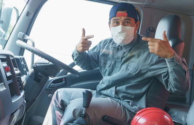 Portrait of young man sitting in car