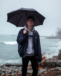 Male standing at beach unbrella