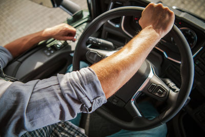 Midsection of man holding steering wheel