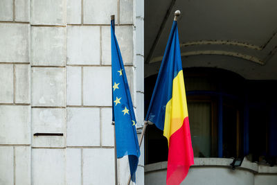 Close-up of national flags hanging against wall