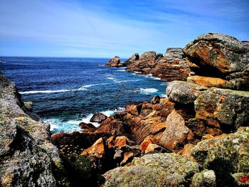 Rock formation on beach against sky