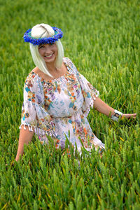 Portrait of smiling woman relaxing on wheat field