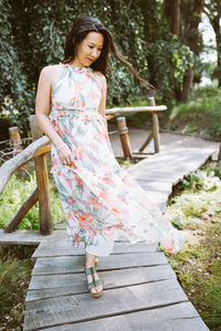 Happy multiracial japanese woman in romantic floral maxi dress in park