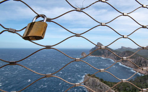 Close-up of chainlink fence against sky