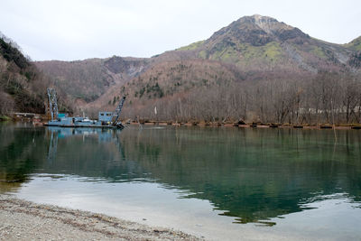 Scenic view of lake by mountains against sky