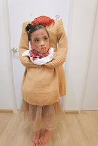 Halloween, portrait of young woman standing against wall