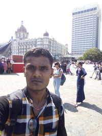 Portrait of young man with city in background