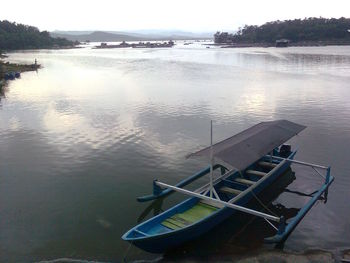 Boat moored on river against sky