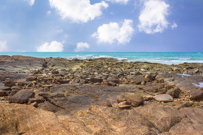 Scenic view of rocks on beach against sky