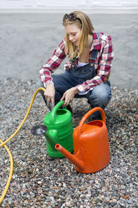 Young woman filling watering cans, stockholm, sweden