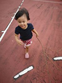 High angle view of smiling girl playing with umbrella