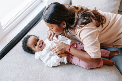 Mother and daughter while sitting on floor