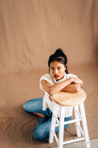 Portrait of young woman sitting on chair