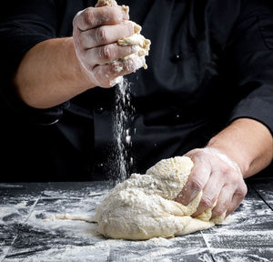 Midsection of male chef preparing food at table