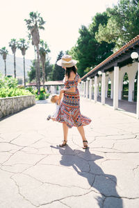 Rear view of woman walking on footpath