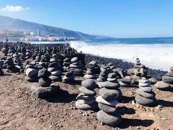 Stack of pebbles on beach against sky