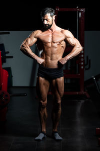 Full length of bodybuilder standing in gym