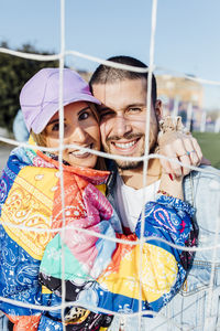 Happy couple. girlfriend and boyfriend on the fence in basketball court