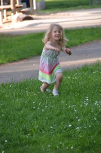 Portrait of cute girl running on grass