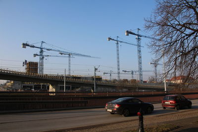 Cars on bridge in city against clear sky