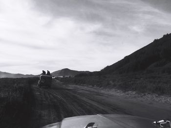 Vehicles on road against sky