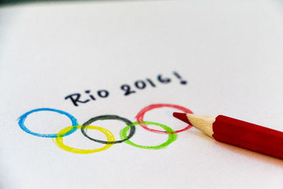 High angle view of text and olympic rings drawn on paper