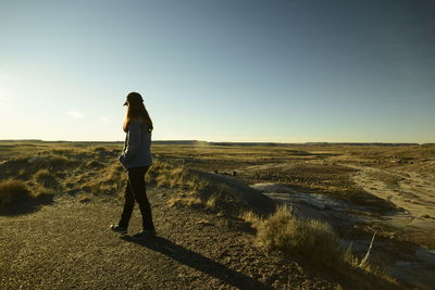 Woman standing on field against clear sky